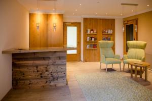 a lobby with a counter with chairs and a table at Hotel Garni Carl Michael in Strobl