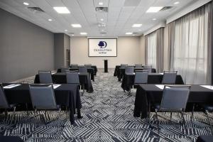 a conference room with black tables and chairs and a screen at DoubleTree by Hilton Hotel Detroit Novi in Novi +31 photos