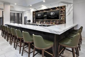 a bar with green chairs and a counter at DoubleTree by Hilton Hotel Detroit Novi in Novi
