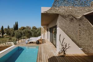 a house with a swimming pool next to a building at Villa Morby in Paleros