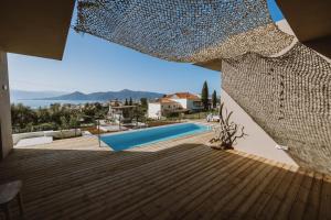 a view from the balcony of a house with a swimming pool at Villa Morby in Paleros