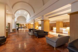 a lobby with couches and chairs in a building at Hilton Rome Airport in Fiumicino +60 photos