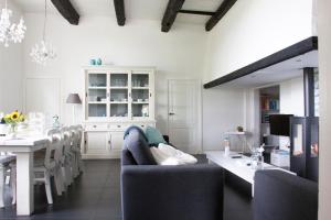 a kitchen and dining room with a couch and a table at De Reggestee in Hellendoorn