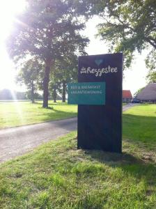 a sign in the grass next to a road at De Reggestee in Hellendoorn