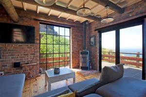 a living room with a couch and a brick wall at Hidden Gem in Cape Town