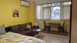 a living room with a couch and a table at Студио in Shumen