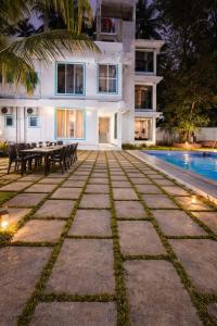 a villa with a swimming pool at night at Bellevue Retreat in Alībāg