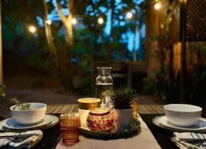 a wooden table with two cups and bowls on it at Fig Tree Rock 2-bed, 2-bath villa with garden and parking in Nelspruit
