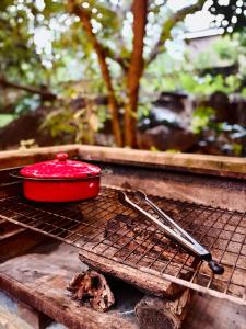 a red pot and tongs sitting on a grill at Fig Tree Rock 2-bed, 2-bath villa with garden and parking in Nelspruit