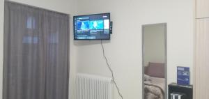 a television hanging on a wall in a living room at elia patra apartment 2 in Patra