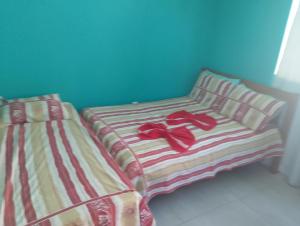 two beds with red shoes on top of them at Casa linda buzios in Búzios