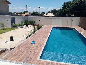 a swimming pool in a backyard with a wooden deck at Casa linda buzios in Búzios +2 photos