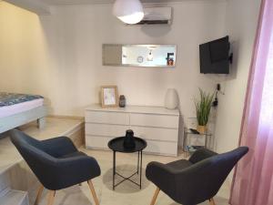 a bedroom with two chairs and a table and a bed at Ivana Apartment in Rabac