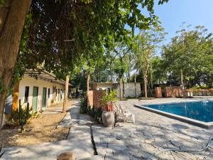 a yard with a swimming pool and a house with a tree at สวนธรรมคยา in Ban Dan Chang