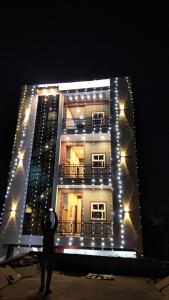 a man standing in front of a building with lights at Hotel Dayalu palace in Vrindāvan