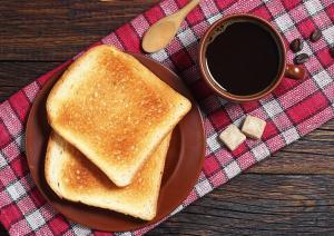 a plate with a piece of toast and a cup of coffee at のあそびlodge in Arao