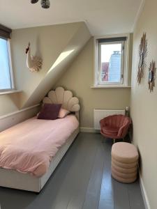 a bedroom with a bed and a chair and windows at Beautiful entire house in the center in Medemblik