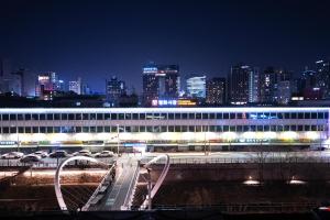 a large building with a city skyline at night at GOYURe 고유리 in Seoul