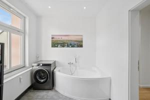 a bathroom with a washing machine and a bath tub at Apartment Alte Bäckerei in Zwenkau