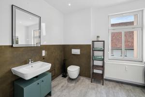 a bathroom with a sink and a toilet and a mirror at Apartment Alte Bäckerei in Zwenkau