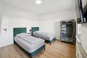a room with two beds and a tv at Apartment Alte Bäckerei in Zwenkau