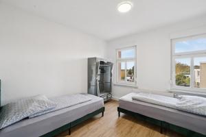 a bedroom with two beds and two windows at Apartment Alte Bäckerei in Zwenkau +29 photos