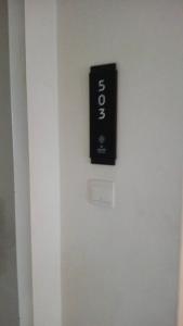 a black sign on the side of a white elevator at D Elite in Kota Bharu