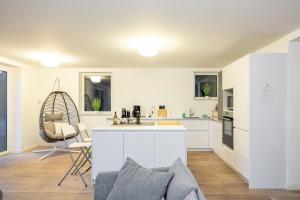 a kitchen with white cabinets and a counter top at Wellnessoase mit Sauna und Garten in Würzburg