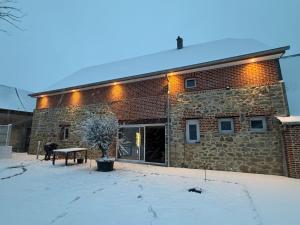 a brick building with a bench in front of it at La ferme des souvenirs in Felleries
