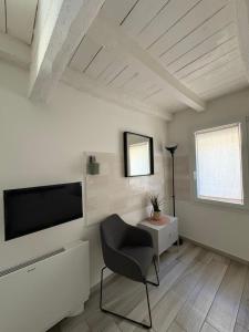 a living room with a television and a chair at Terrazza Montegrappa in Reggio Emilia