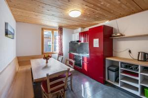 a kitchen with a table and a red refrigerator at Bed and Breakfast Bauernhof Bättwil in Burgdorf