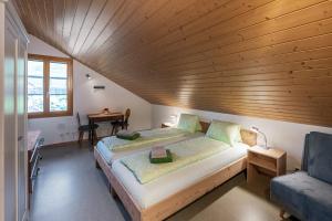 a bedroom with a large bed with a wooden ceiling at Bed and Breakfast Bauernhof Bättwil in Burgdorf