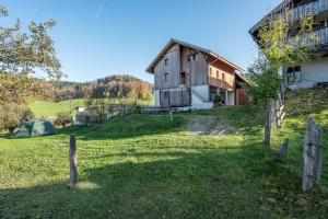 an old barn and a tent on a field at Bed and Breakfast Bauernhof Bättwil in Burgdorf