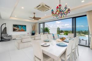 a dining room and living room with a chandelier at Stunning X Space Villa Sea View Infinity Pool in Koh Samui