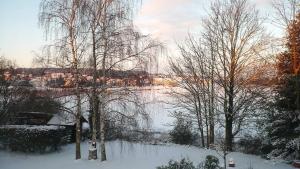 a snow covered field with trees and a river at Le Logis d Orgeval in Orgeval +3 photos