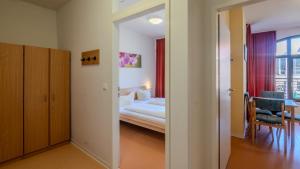 a bedroom with a bed and a dining room at DJH Jugendherberge Görlitz Altstadt in Görlitz