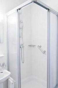 a shower with a glass door next to a sink at Stylish Duplex Apartment in Morges +6 photos