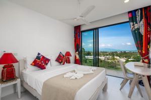 a bedroom with a bed and a table and a large window at Stunning X Space Villa Sea View Infinity Pool in Koh Samui +29 photos