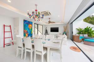 a dining room with a white table and chairs at Stunning X Space Villa Sea View Infinity Pool in Koh Samui