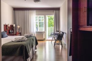 a hotel room with two beds and a balcony at Best Western Solhem Hotel in Visby