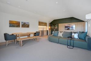 a living room with a blue couch and a table at Luna Lodge Wānaka - digital check-in only in Wanaka