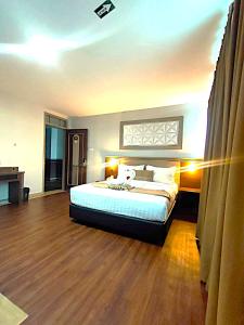 a bedroom with a large bed and a wooden floor at Aamina Syariah Balikpapan in Klandasan-besar +9 photos