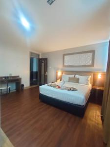 a bedroom with a bed and a desk in it at Aamina Syariah Balikpapan in Klandasan-besar