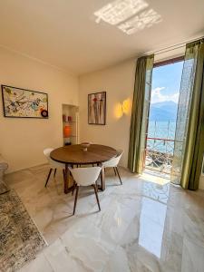 ein Esszimmer mit einem Tisch und einem großen Fenster in der Unterkunft Casa Giulia in Dongo + 16 Fotos
