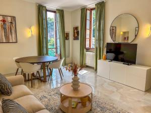 ein Wohnzimmer mit Sofa, Fernseher und Tisch in der Unterkunft Casa Giulia in Dongo