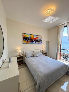 ein Schlafzimmer mit einem großen Bett und einem großen Fenster in der Unterkunft Casa Giulia in Dongo