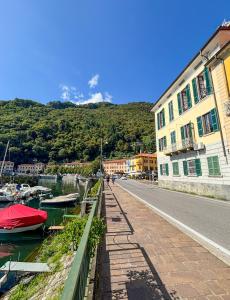 eine Straße mit Booten im Wasser neben Gebäuden in der Unterkunft Casa Giulia in Dongo