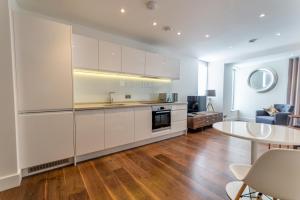 a kitchen with white cabinets and a table in a room at Castle Chambers in York