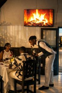 a man standing next to a man sitting at a table at La Dukes Resort in Bushman Rock