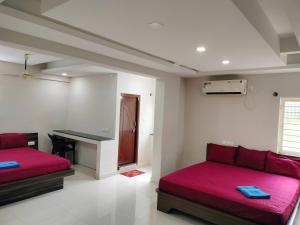 a room with two beds and a desk in it at Hotel Jaganmatha Kollur in Kollūru